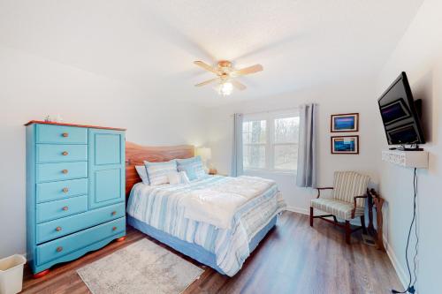 a bedroom with a bed and a blue dresser and a television at Chatuge Bell in Hiawassee