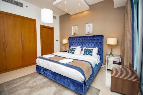a bedroom with a blue bed with a blue headboard at Stylish and Sleek 1 Bed + Study near the JBR beach in Dubai