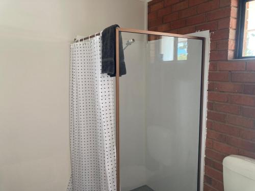 a shower stall with a toilet and a shower curtain at Berrigan Motel in Berrigan