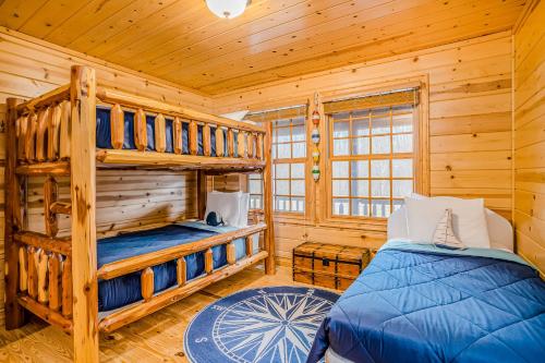 a bedroom with two bunk beds in a log cabin at Kingfisher Cove Cabin 19 in Saugatuck