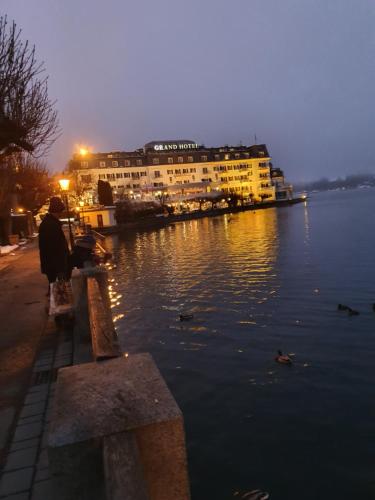 a person sitting on a bench next to a body of water at Appartement Pension Bäckenhäusl FERIENWOHNUNGEN Chalets Hütten Komfortzimmer in Uttendorf
