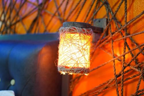 a light bulb hanging from a chain link fence at CLOCKWORKORANGE Luxury Suites 4-Minutes Away To Airport in Mactan