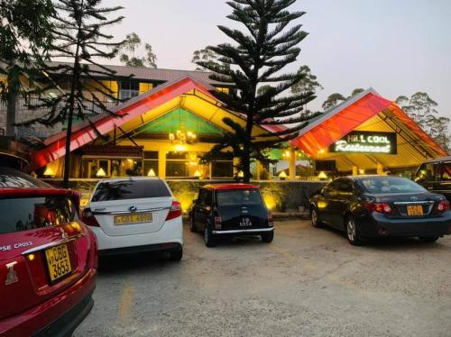 a group of cars parked in front of a restaurant at Hill Cool Hotel & Restaurant in Hatton