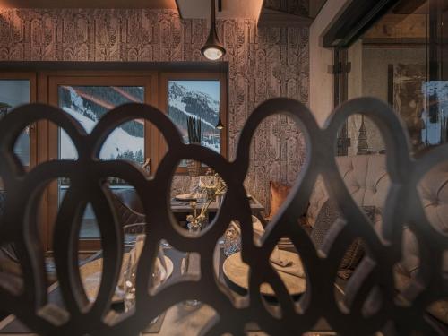 a view through a wrought iron fence of a room with mountains at Hotel Bergkristall Zillertal - Adults Only in Hippach