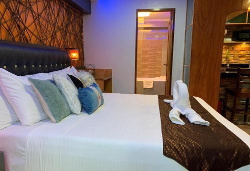 a bedroom with a bed with two slippers on it at CLOCKWORKORANGE Luxury Suites 4-Minutes Away To Airport in Mactan