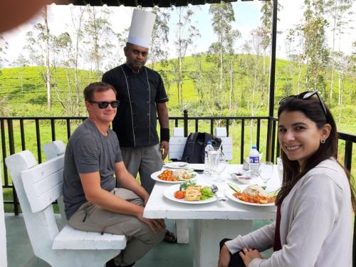 a group of people sitting at a table with food at Hill Cool Hotel & Restaurant in Hatton