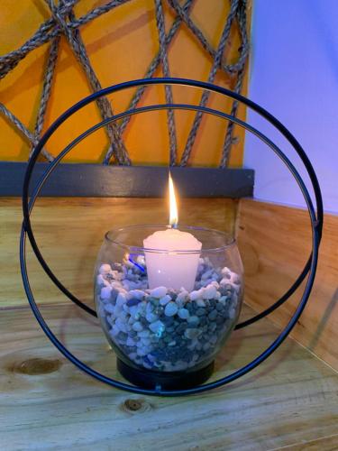a candle in a glass bowl with rocks at CLOCKWORKORANGE Luxury Suites 4-Minutes Away To Airport in Mactan