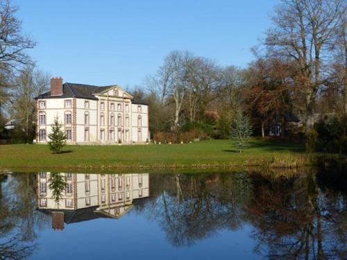 una grande casa con il suo riflesso nell'acqua di Chambre E André Le Domaine Des Jardins De Bracquetuit a Bracquetuit