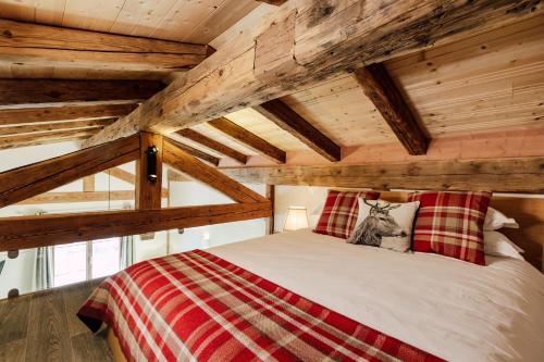 Cama en habitación con techo de madera en Petit Lumina en Morzine