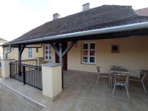 a patio with a table and chairs and a house at Apartmanház Mohács in Mohács