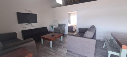 a living room with a couch and a tv at Breede River View with mooring at Witsand,Self-Catering Apartment in Witsand