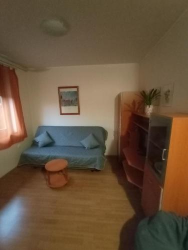 a small room with a blue bed and a tv at Apartmanház Mohács in Mohács
