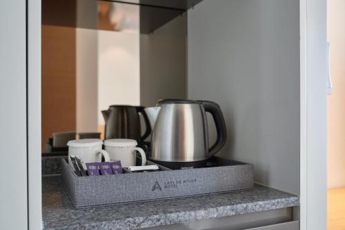 a tray with cups and a tea kettle on a counter at Lavi De Atlan Hotel 2 in Busan