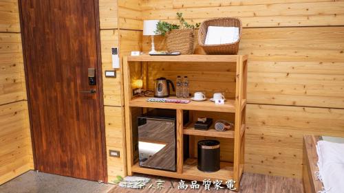 阿里山にあるAlishan Hinoki B&Bの木製の壁の客室で、小さなキャビネットが備わります。