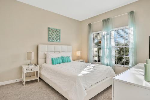 een witte slaapkamer met een groot bed en 2 ramen bij Endless Magic in Kissimmee