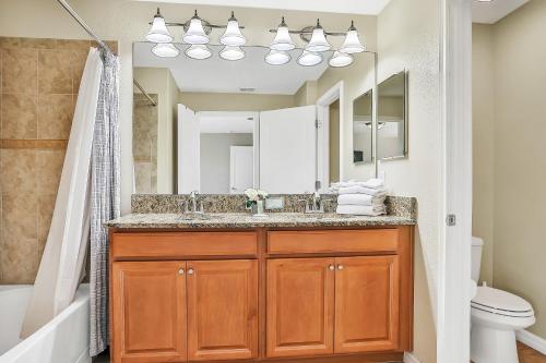 een badkamer met een wastafel en een spiegel bij Endless Magic in Kissimmee