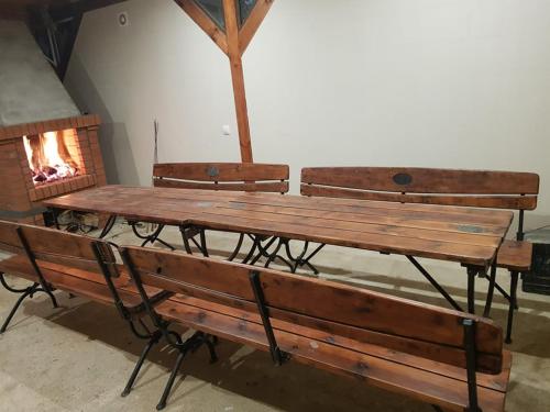 a wooden table and benches with a fire place at Dom pod Wierzbami in Gołdap