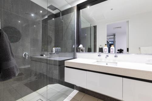 ein Badezimmer mit zwei Waschbecken und einem großen Spiegel in der Unterkunft The Port Melbourne Experience in Melbourne