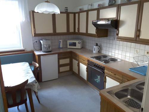 a small kitchen with wooden cabinets and a table at Gaßmayr in Lienz