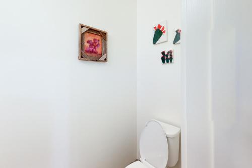 a bathroom with a toilet and some pictures on the wall at Menlo Magic in Tucson