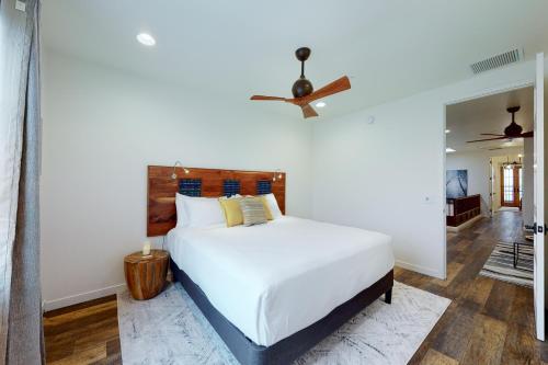 a bedroom with a white bed and a ceiling fan at Menlo Magic in Tucson