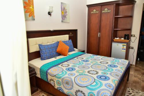 a bedroom with a bed with blue and orange pillows at Grand Hotel Ras Elbar in Ras El Bar