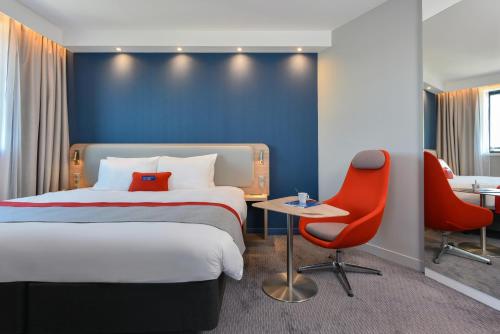 a hotel room with a bed and a desk and a chair at Holiday Inn Express - Rouen Centre - Rive Gauche by IHG in Rouen