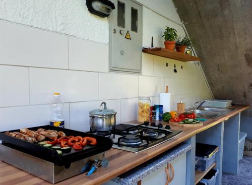 a kitchen with a stove top with vegetables on it at SočaLand Glamping in Bovec