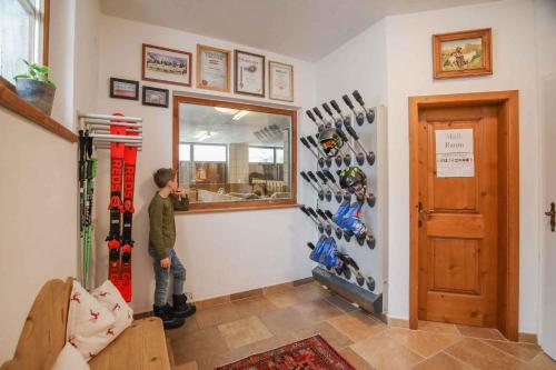 a man standing in a room with skis on the wall at Landhaus Wildes Wasser in Neustift im Stubaital