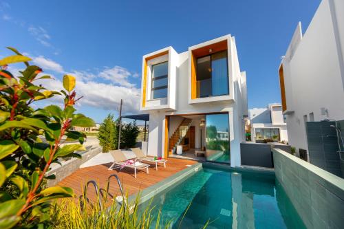 a villa with a swimming pool and a house at Villa Laurus 6, walking distance to the beach in Paphos