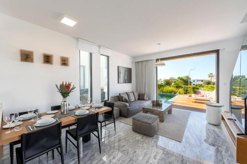 a living room with a dining table and a couch at Villa Laurus 6, walking distance to the beach in Paphos