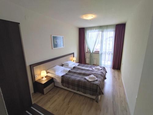 a bedroom with a bed and a large window at Nevada Aparthotel in Pamporovo