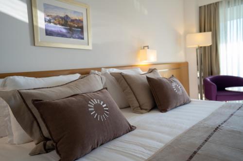 a bedroom with a bed with brown and white pillows at ON'LIVE HOTEL in Cesme