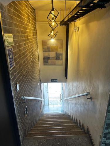 a hallway with stairs and a brick wall at HOTEL MEDELLIN CENTRAL in Medellín