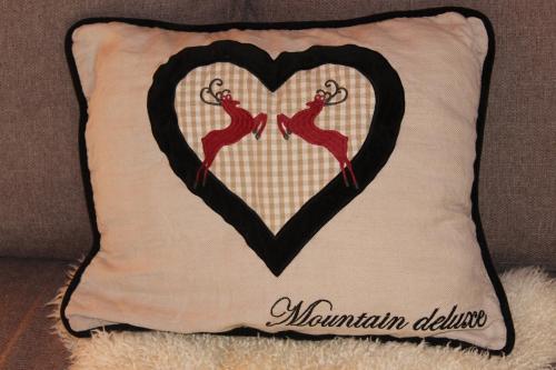 a pillow with a heart on a couch at Lilly Chalet- Apartments with private sauna, close to ski lifts in Bad Kleinkirchheim