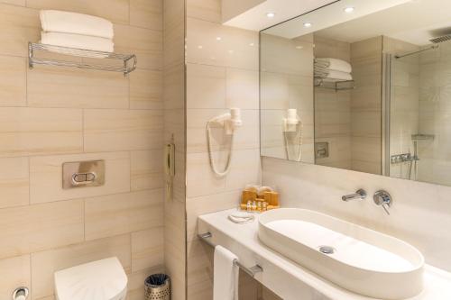 a white bathroom with a sink and a shower at ON'LIVE HOTEL in Cesme