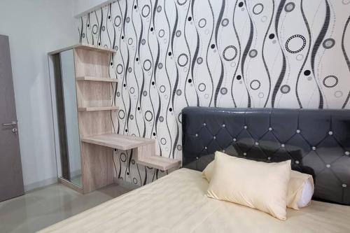 a bedroom with a bed with a black head board at Apt Vasanta Inopark 1 BR Lnd4 dgn Infinity Pool, Onsen dan Netflix in Jarakasta