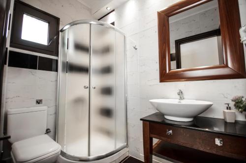 a bathroom with a glass shower and a sink at 4-you Residence in Ayios Nikolaos Sithonia
