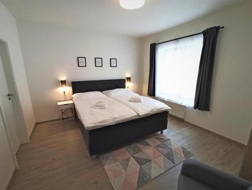 una camera con un letto e una grande finestra di Lipno Port Apartment A103 a Lipno nad Vltavou