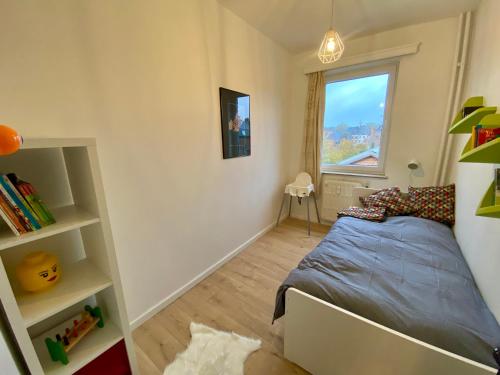 - une petite chambre avec un lit et une fenêtre dans l'établissement Appartement lumineux, idealement situe - Enfants bienvenus ACTIVITES COMMERCIALES OU REMUNEREES INTERDITES, à Namur