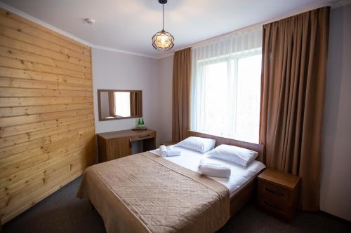 a bedroom with a bed and a large window at Князів Двір in Bukovel