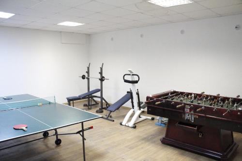 a gym with a ping pong table and exercise equipment at Nevada Aparthotel in Pamporovo