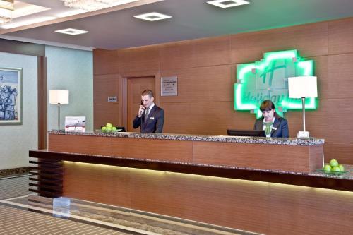 a man standing in front of a counter in a restaurant at Holiday Inn Ankara-Kavaklidere, an IHG Hotel in Ankara