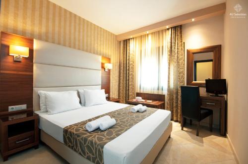 Pokój hotelowy z łóżkiem, biurkiem i telewizorem w obiekcie 4-you Residence w mieście Ajos Nikolaos