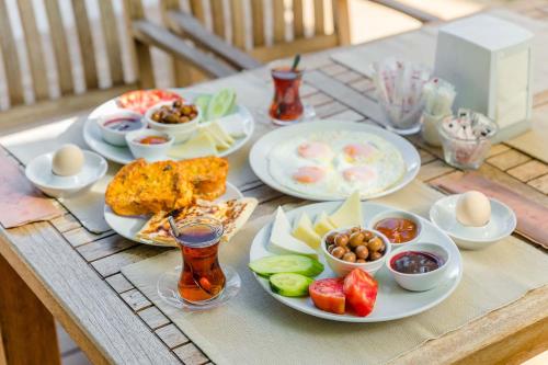 a table with plates of food and bowls of fruit at Vira Suites Hotel in Göcek