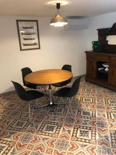 - une table et des chaises en bois dans l'établissement Charmante maison de village avec toit terrasse, à Montalba-le-Château