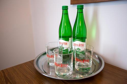 two green bottles and two glasses on a tray at Князів Двір in Bukovel