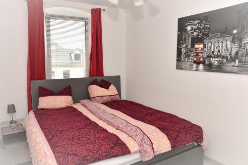 1 cama en un dormitorio con una foto en la pared en Ferienwohnung und Apartment Löbau, Stadt- und messenah, en Löbau