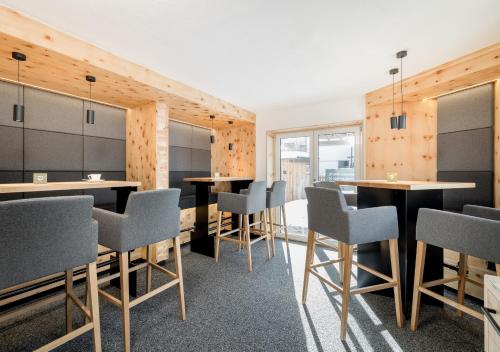 ゼルデンにあるApart Garni Enzianの木製の壁、テーブルと椅子が備わる客室です。