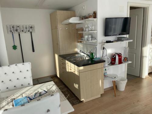 a kitchen with a counter and a tv in a room at Hälmli in Heiden